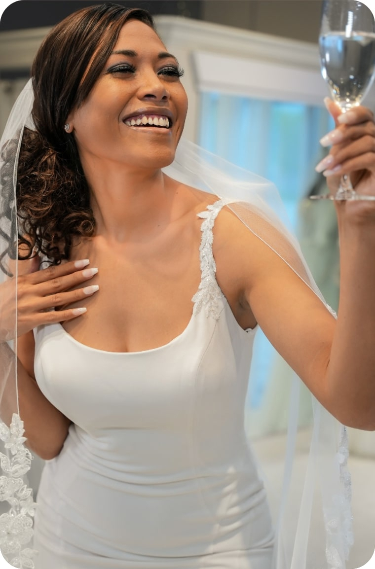Model wearing white bridal gown with a glass of wine - Mobile Image
